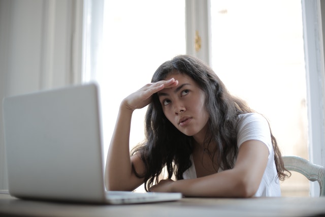 woman stressed next to laptop